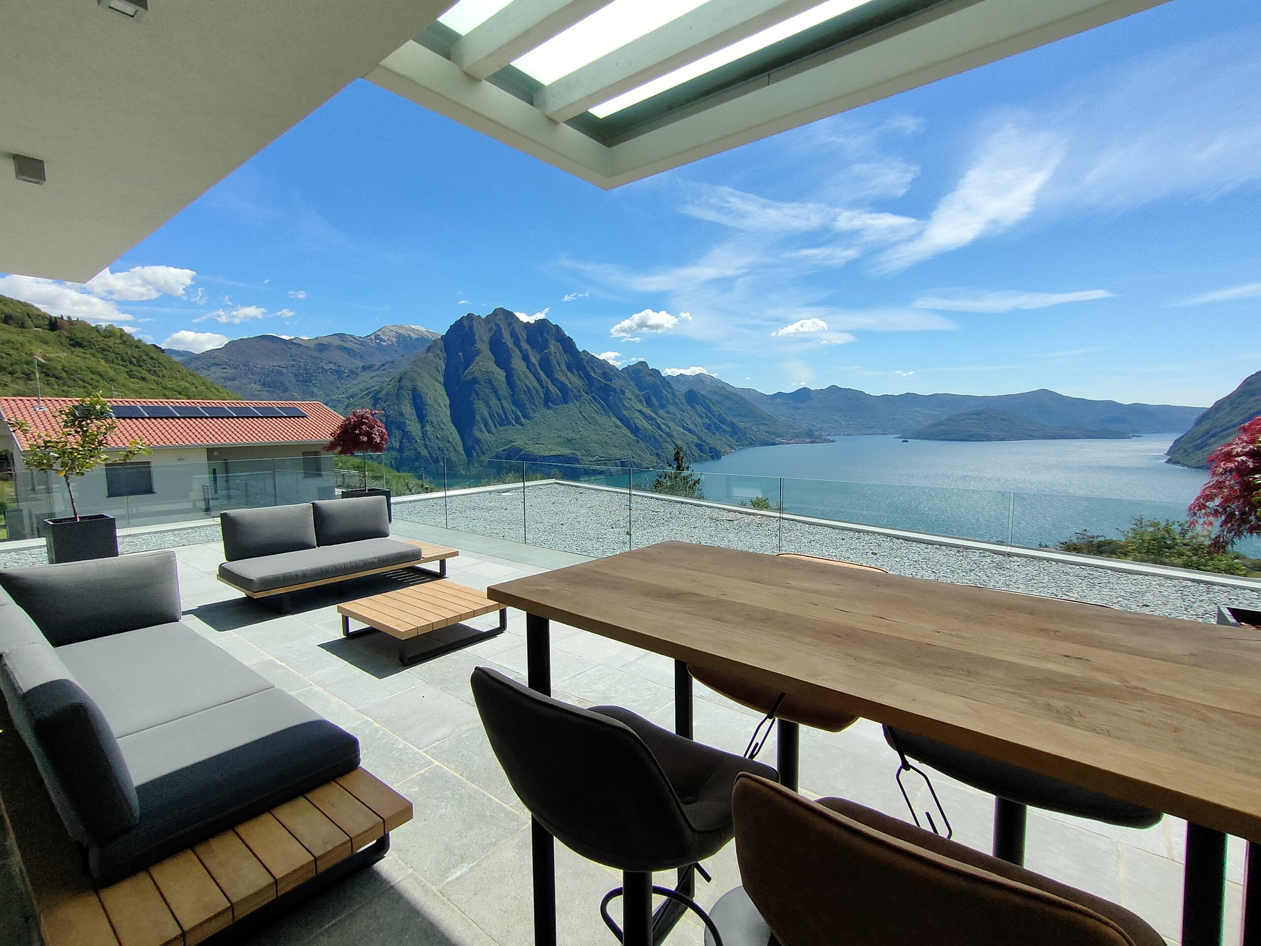 Stylish outdoor seating on a terrace with a stunning view of Lake Iseo and the mountains