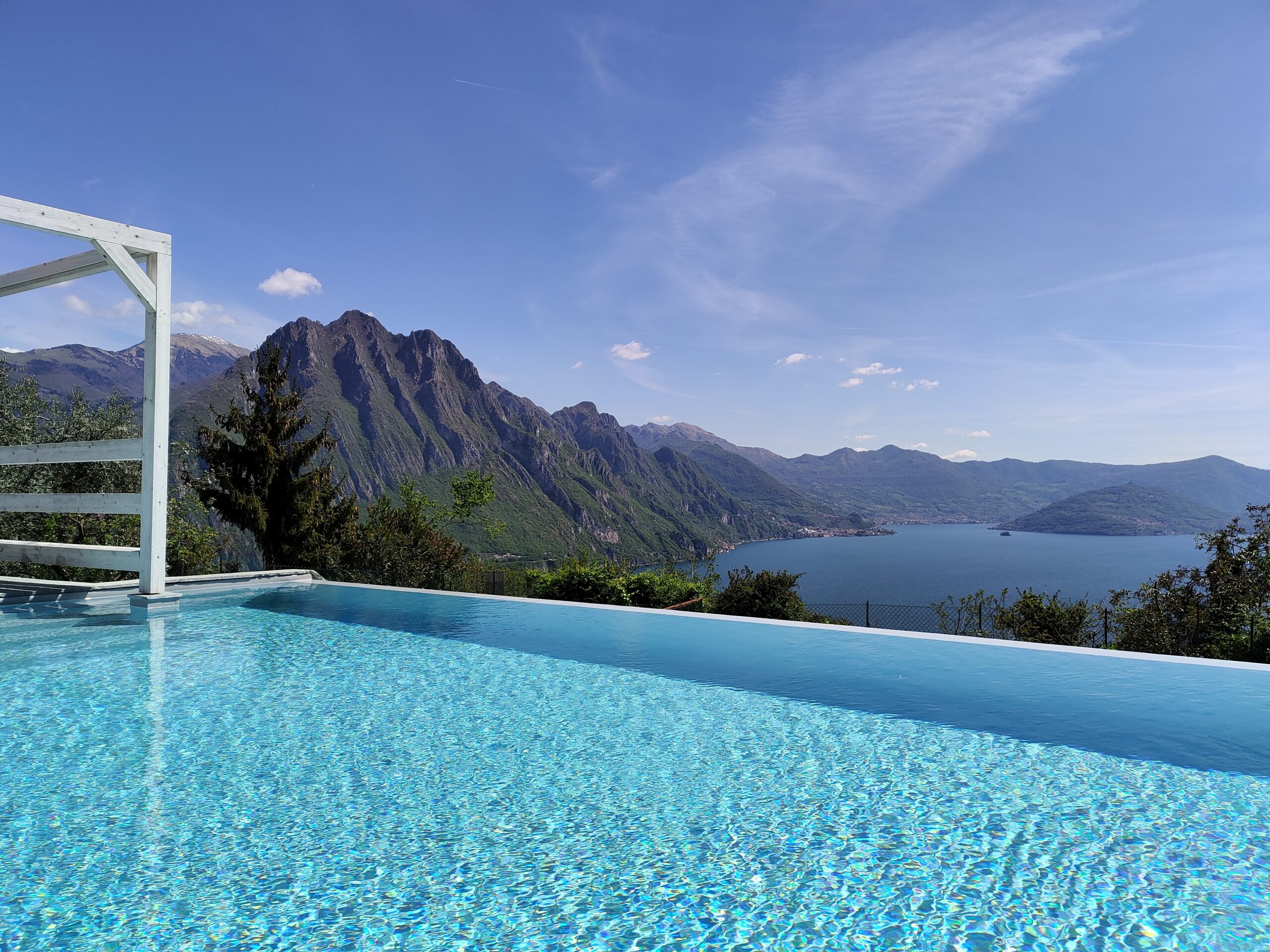 Calm blue waters of the pool with a scenic view of Lake Iseo at Fabula Home Rental