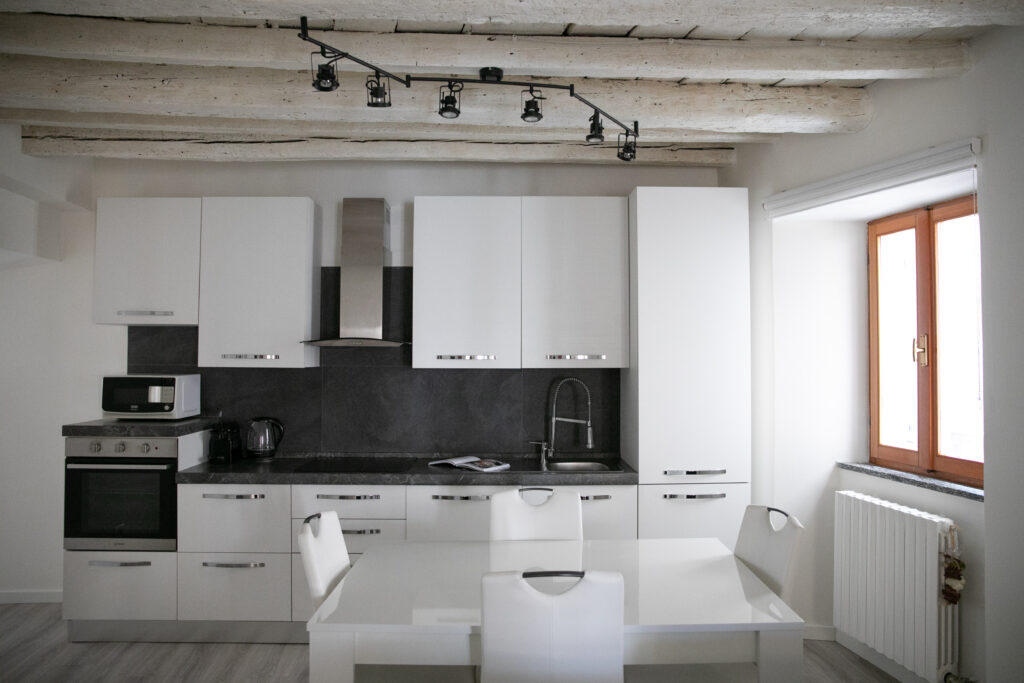 Fully equipped white kitchen in Casa Lu Lovere apartment with modern appliances