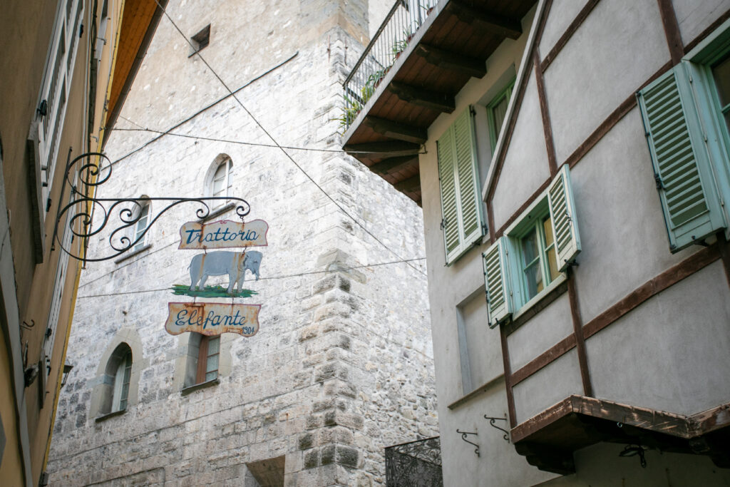 Historic trattoria sign with an elephant illustration on an ancient stone wall in Lovere