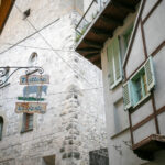 Historic trattoria sign with an elephant illustration on an ancient stone wall in Lovere