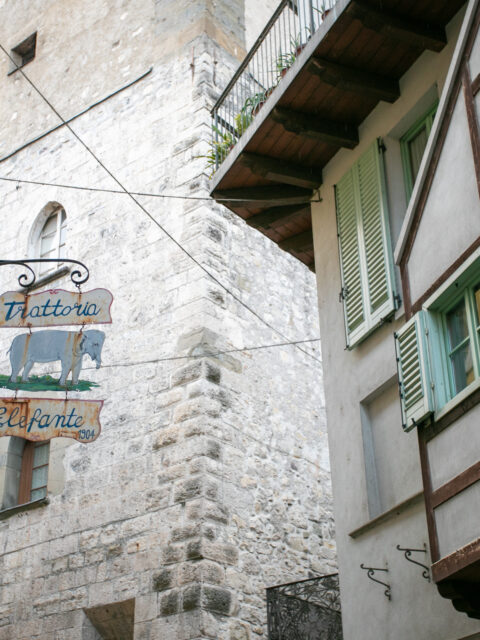 Historic trattoria sign with an elephant illustration on an ancient stone wall in Lovere