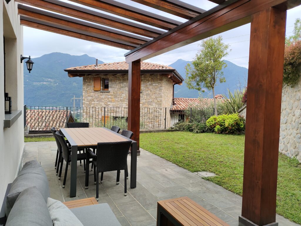 A lush garden view with pergola at Casa Cuneo, part of Fabula Home Rental's collection