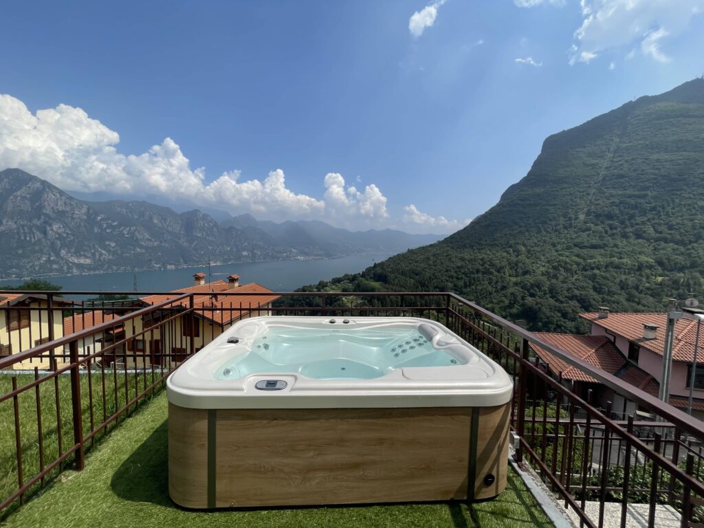 Private jacuzzi of Casa il Nido featuring serene Lake Iseo in the distance, a Fabula Home Rental property