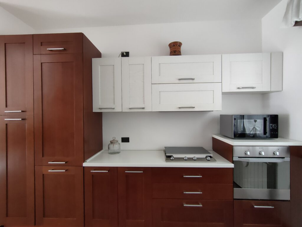 Close-up of GiannaRosa Apartment's kitchen with stylish white upper cabinets and modern appliances in Lovere