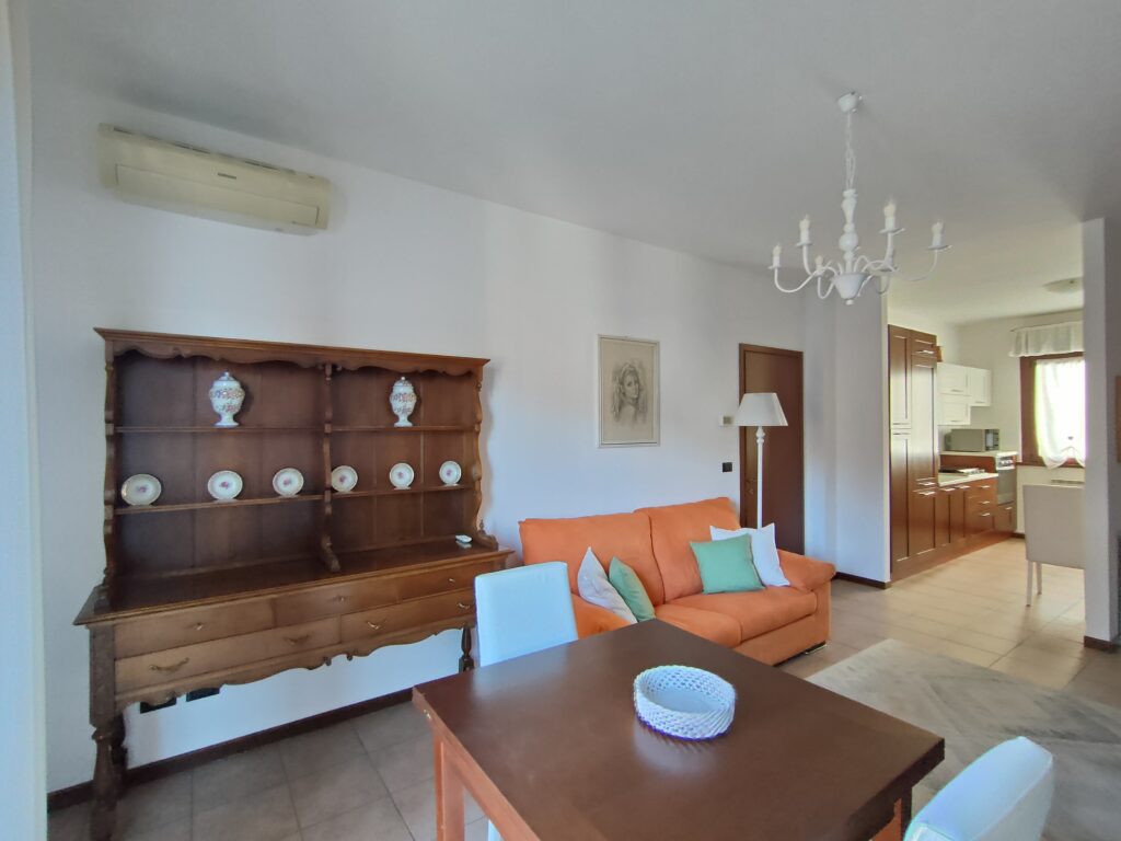 Elegant living and dining area with balcony access in GiannaRosa Apartment, overlooking Lovere's beauty