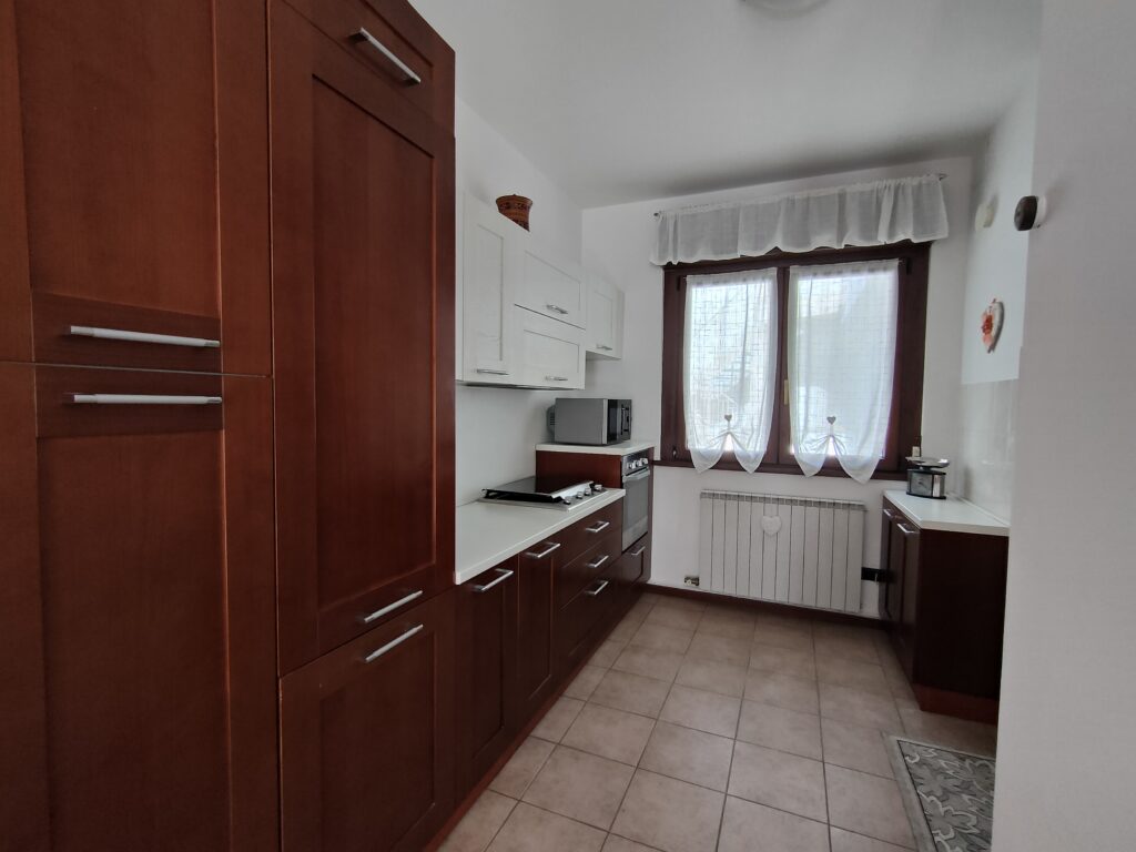 Modern kitchen in GiannaRosa Apartment featuring a combination of white and wooden cabinetry in Lovere