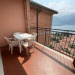 Cozy balcony with table and chairs overlooking Lake Iseo