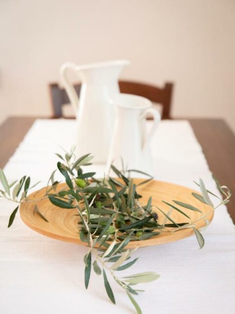 Close-up of La Stallina Primo Piano's dining table with olive branch centerpiece