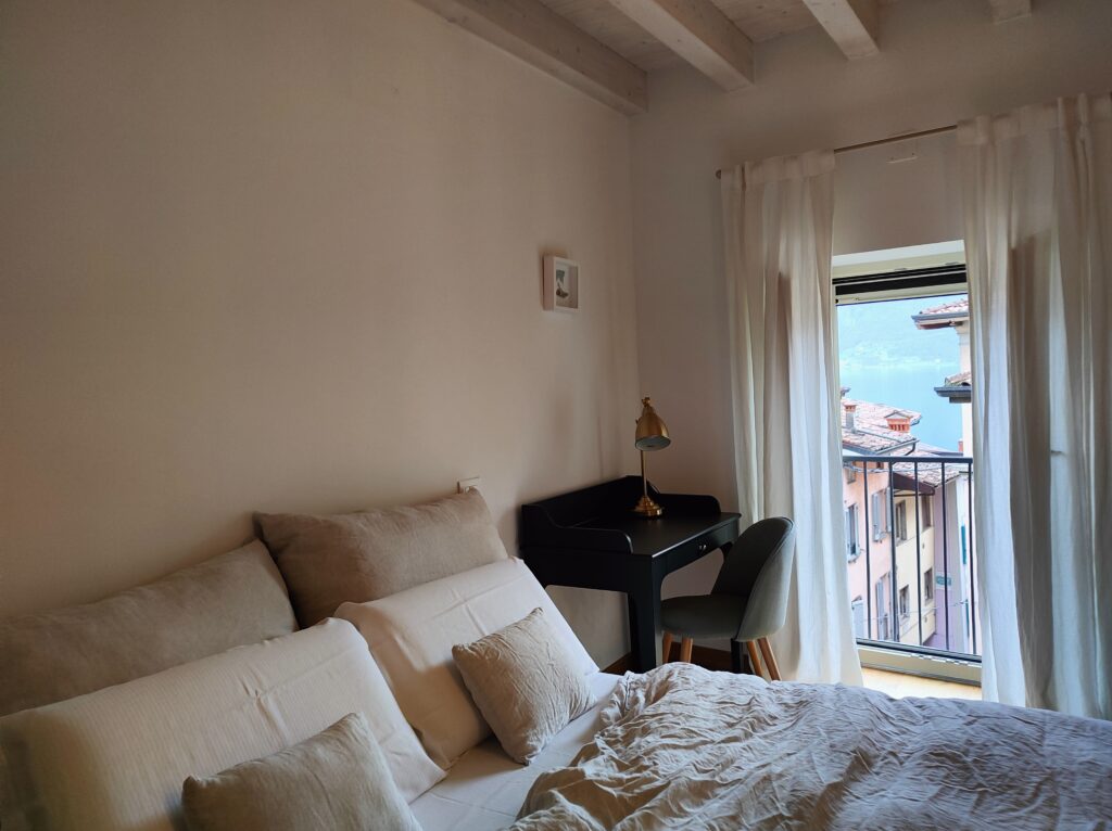 Stylish workspace in the Lakeview Apartment bedroom with a scenic lake view through the open window