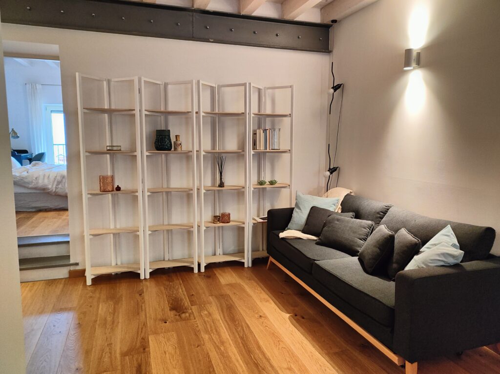 Elegant living room in Lakeview Apartment with white shelving and chic furnishings