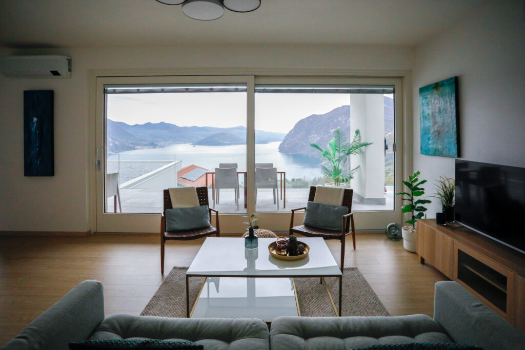 Elegant living room in modern decor with a clear view into the white kitchen space