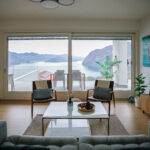 Elegant living room in modern decor with a clear view into the white kitchen space