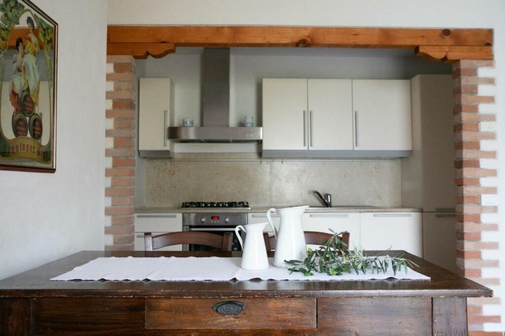 Traditional kitchen with a rustic brick arch and modern amenities at La Stallina Ground Floor