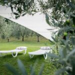 Relaxing white sun loungers in an olive garden with lake views at La Stallina