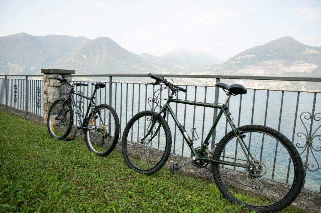 Two bicycles leaning against the railing with panoramic lake and mountain views at La Stallina Ground Floor