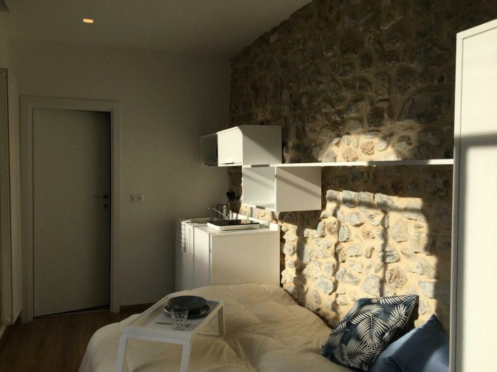 Morning light illuminates the unique stone wall in the studio of Palazzo Cinquecento Depandance