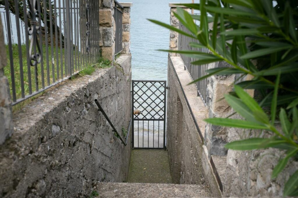 Private gated access to Lake Iseo from La Stallina Ground Floor, framed by lush greenery