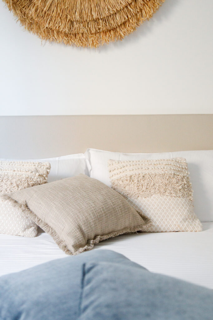 Elegant bedroom pillows against a straw wall decor at Seliera, Iseo Lake