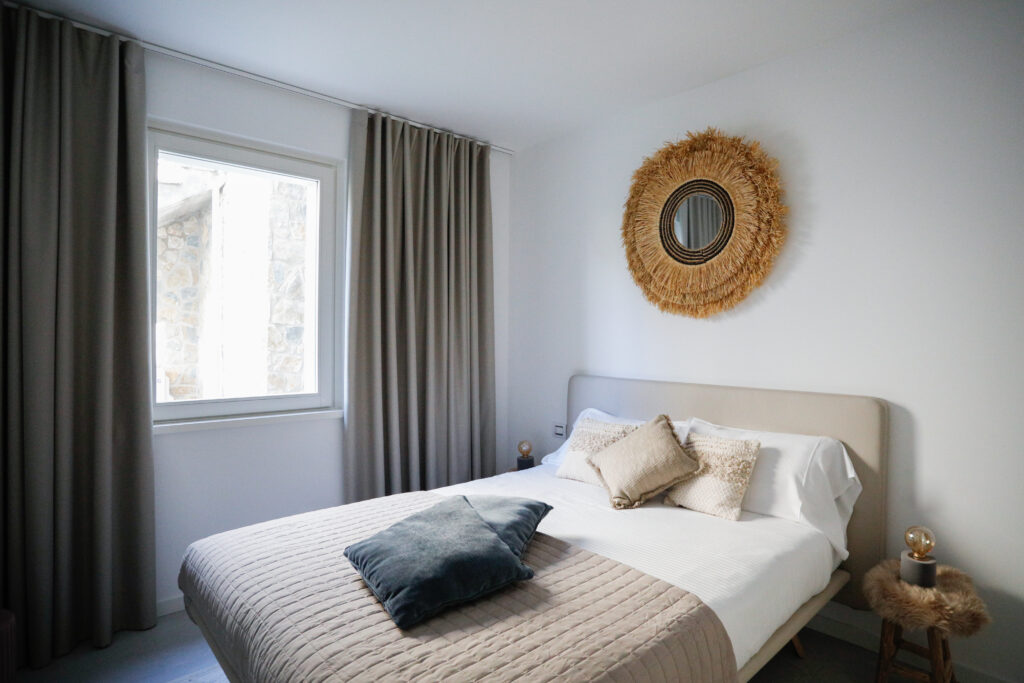 Cozy bedroom in Seliera with a straw wall ornament reflecting Iseo Lake's natural ambiance