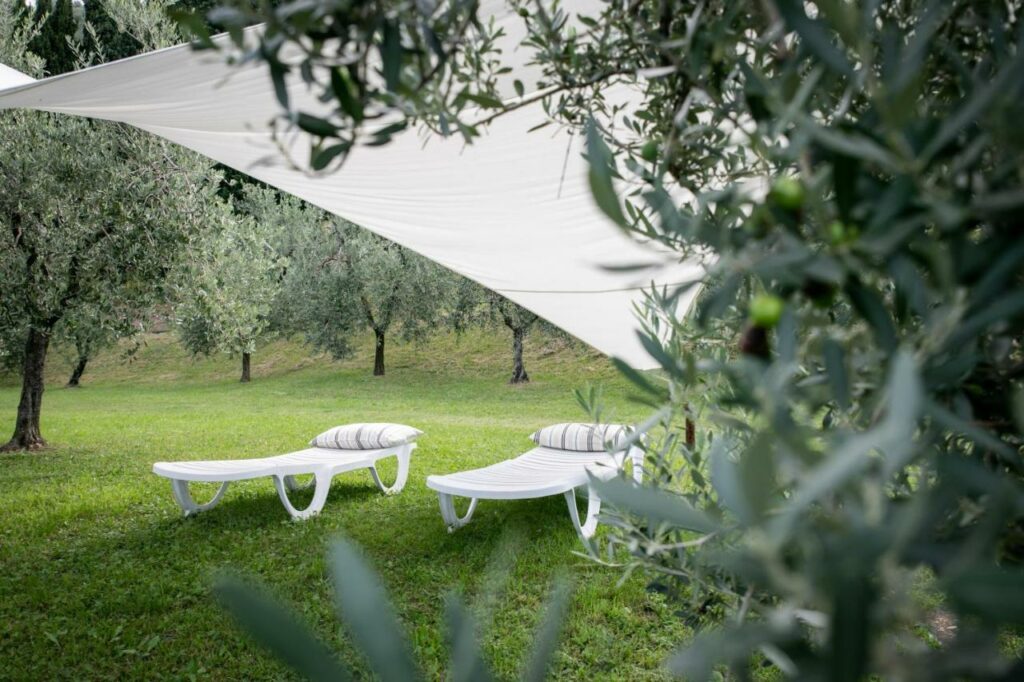 Tranquil outdoor relaxation area with shaded loungers overlooking Lake Iseo at La Stallina Ground Floor