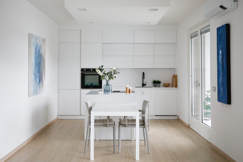 Contemporary white dining kitchen with a view of the lake through the window