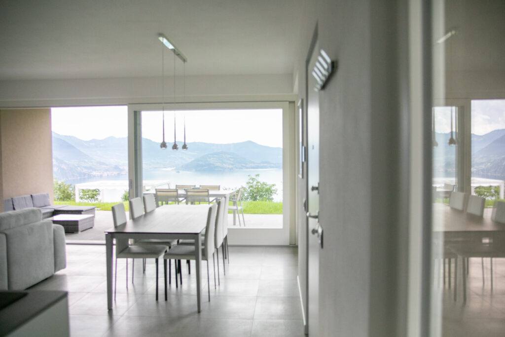 Open-plan living and dining area in a modern design with an uninterrupted view of Lake Solto