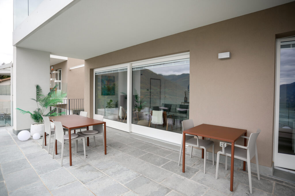 Modern dining table on Trivia Bellavista's terrace overlooking the lake and mountains