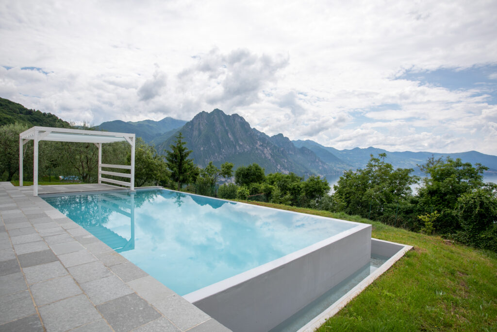 A bright bedroom at Trivia Resort, with a comfortable bed and a stunning view of Lake Iseo