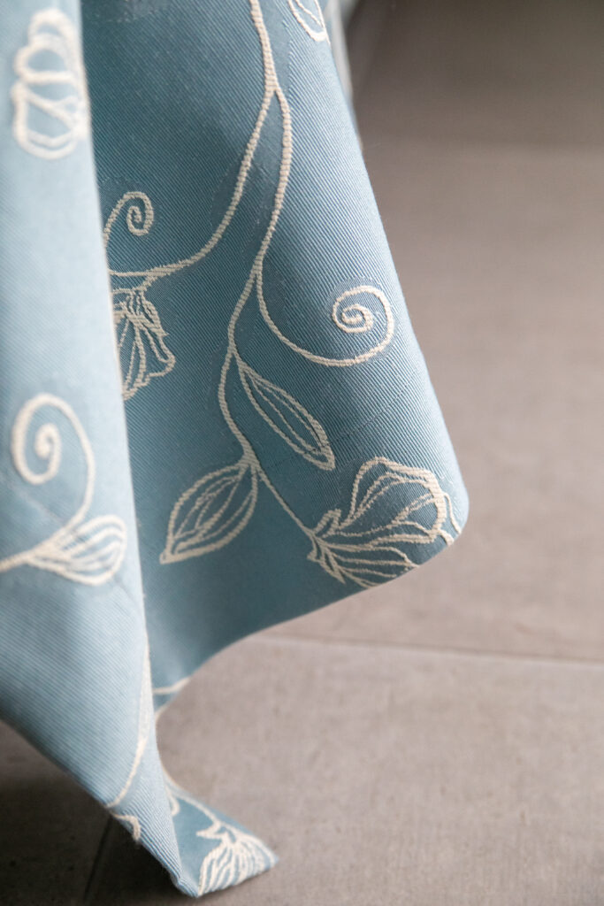 Close-up of a beautifully patterned blue bedspread in a bedroom at Trivia Resort, illustrating attention to detail