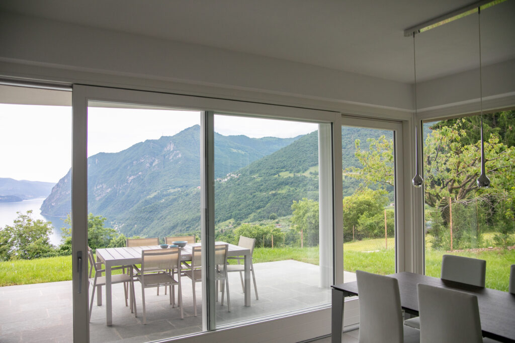 Spacious dining area at Trivia Resort with panoramic views of Lake Iseo through floor-to-ceiling windows