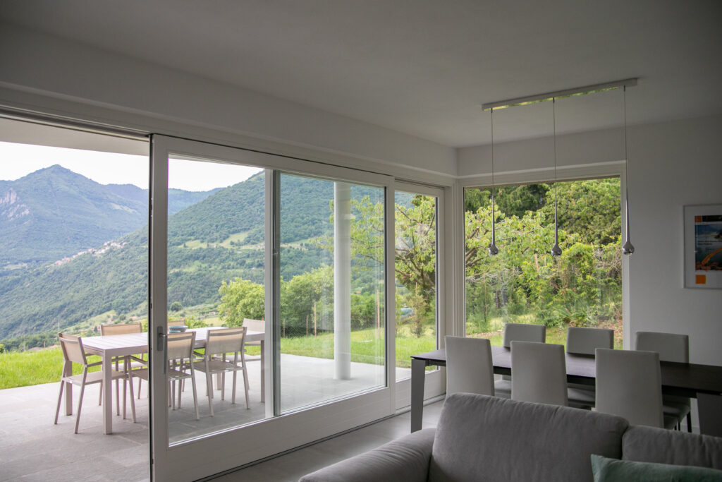 Elegant, modern living space at Trivia Resort, with full-length windows showcasing Lake Iseo