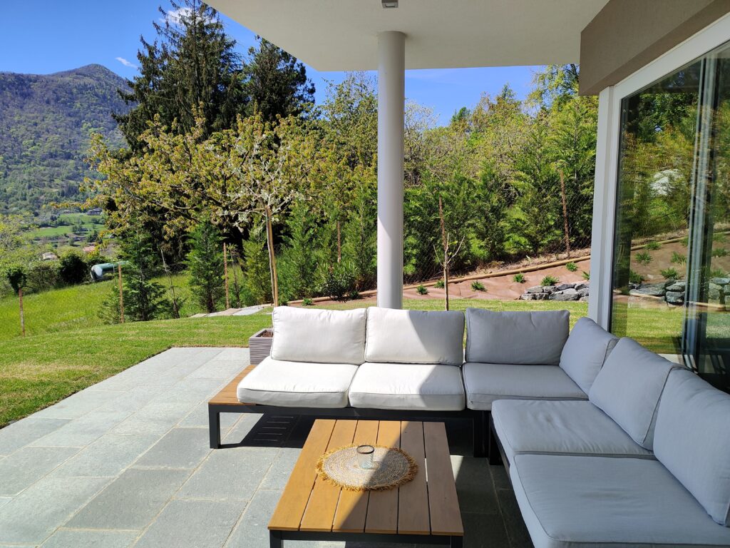 Elegant patio lounge at Trivia Resort with plush sofas and a wooden coffee table overlooking lush greenery