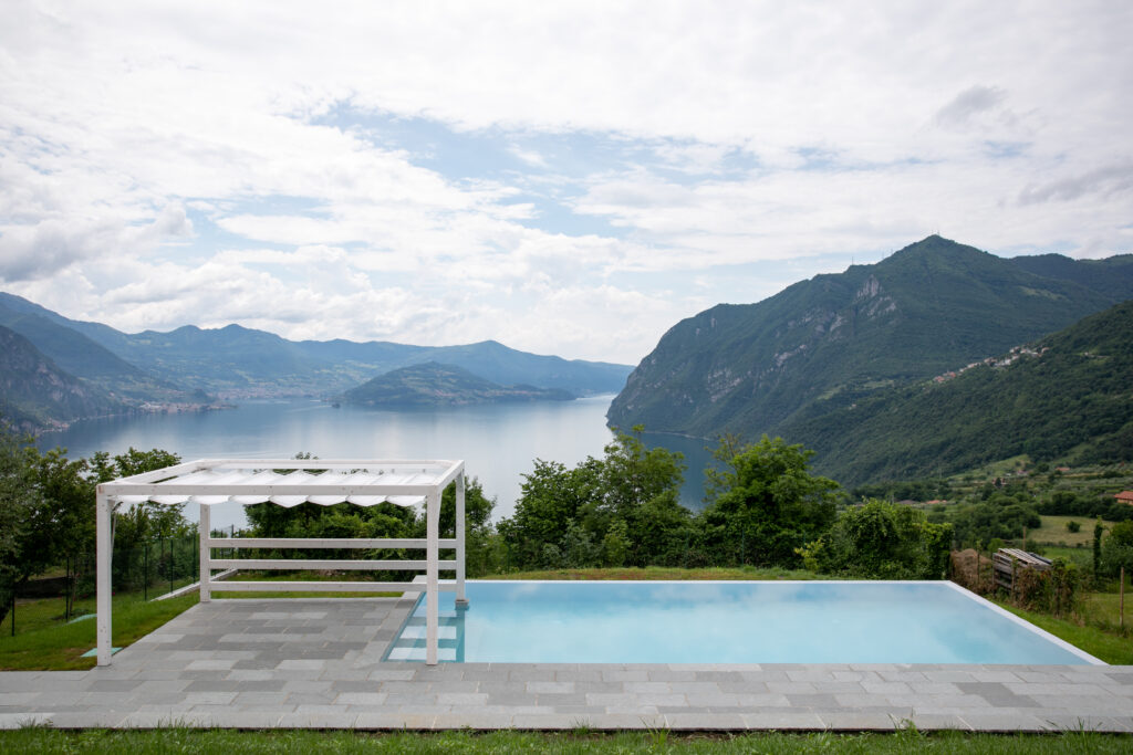 The full panorama of Trivia Resort's poolside pergola with the vast Lake Iseo and surrounding mountains