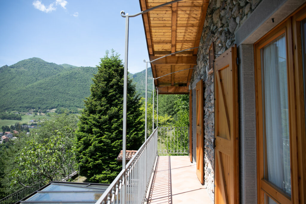 Villa Simone's balcony view showcasing the mountainous backdrop and lush treetops