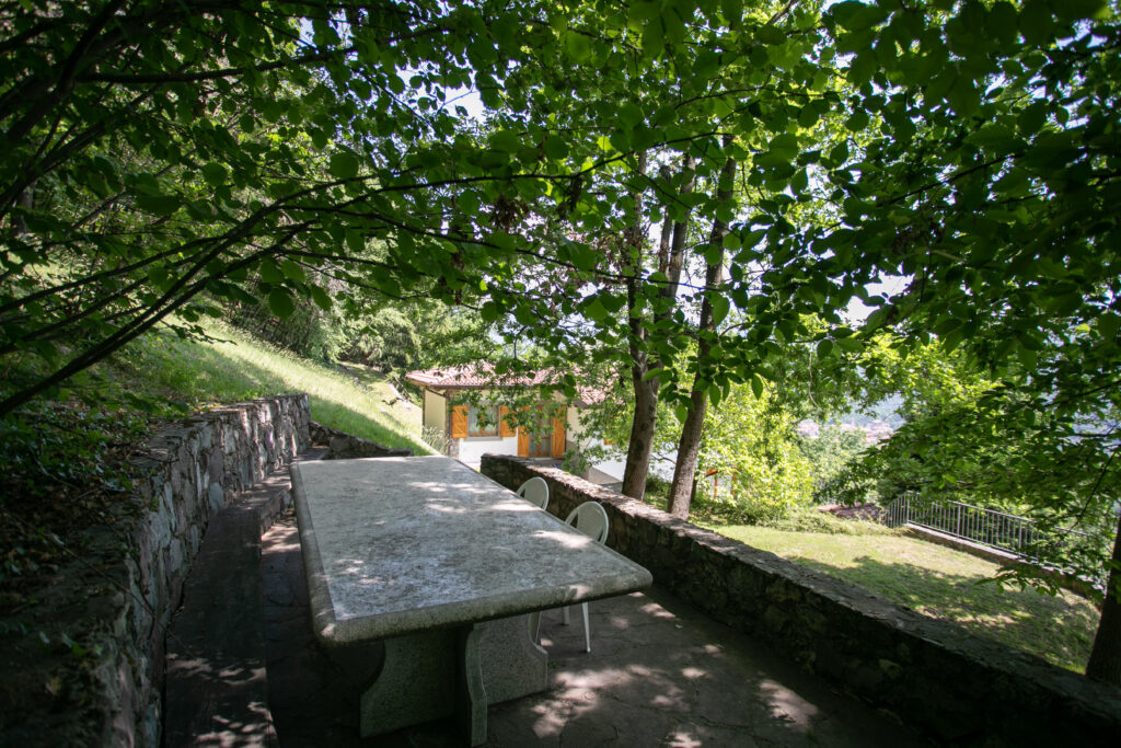 Shaded stone table in the leafy garden of Villa Simone, ideal for outdoor dining and relaxation