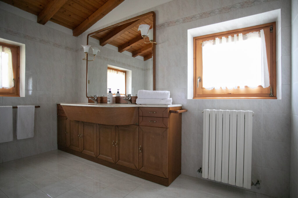 Bathroom in Villa Simone with wooden cabinetry and beam ceiling