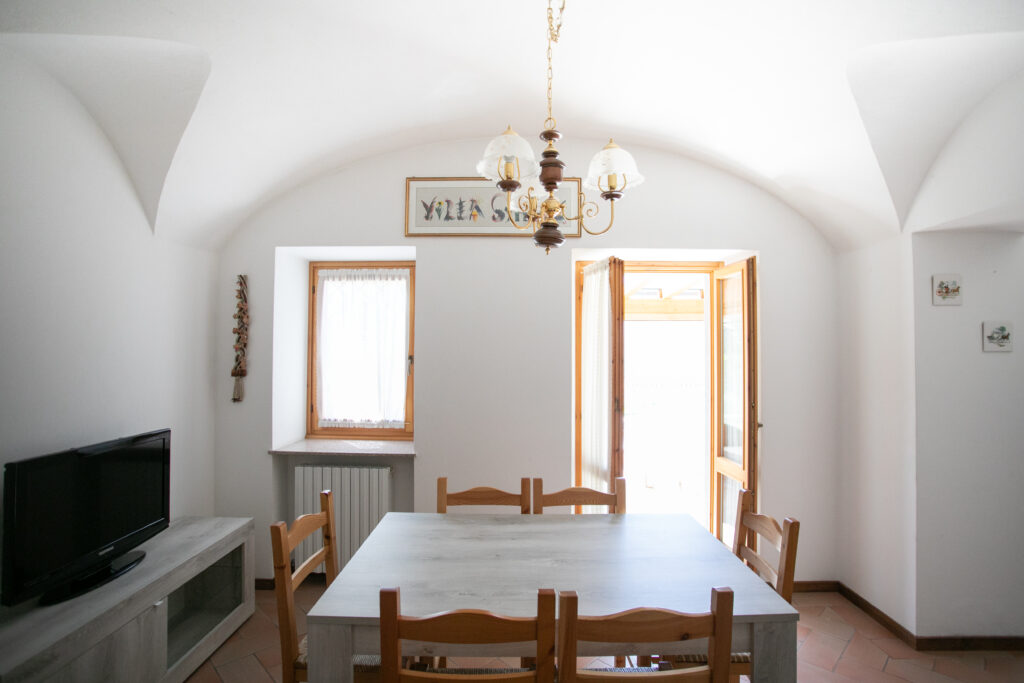 Bright dining space with white arched ceilings and garden access in Villa Simone