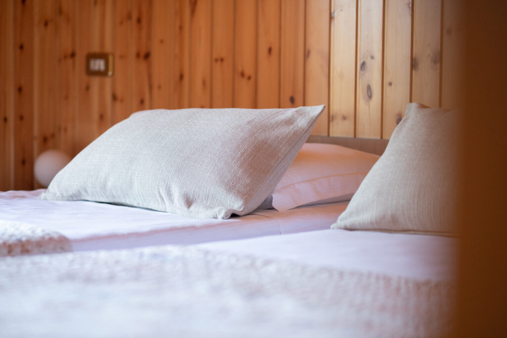 Close-up of twin beds with plush bedding in Villa Simone's rustic bedroom