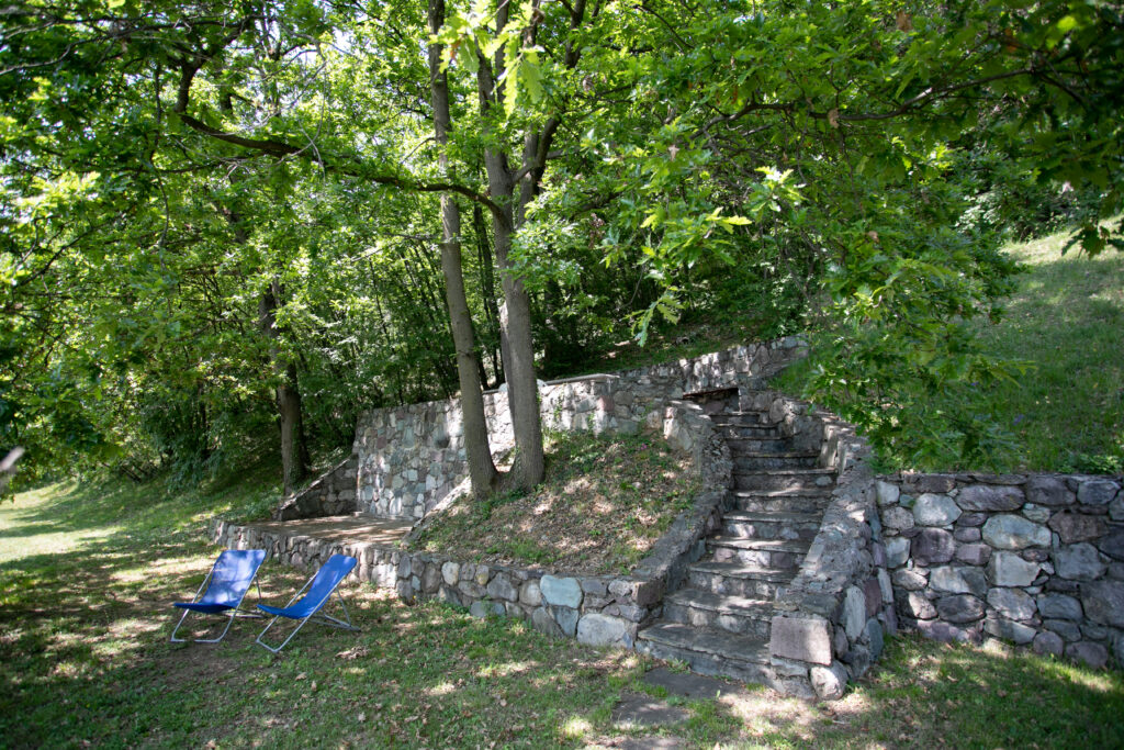 Shaded garden nook with stone stairs and relaxing sun loungers at Villa Simone