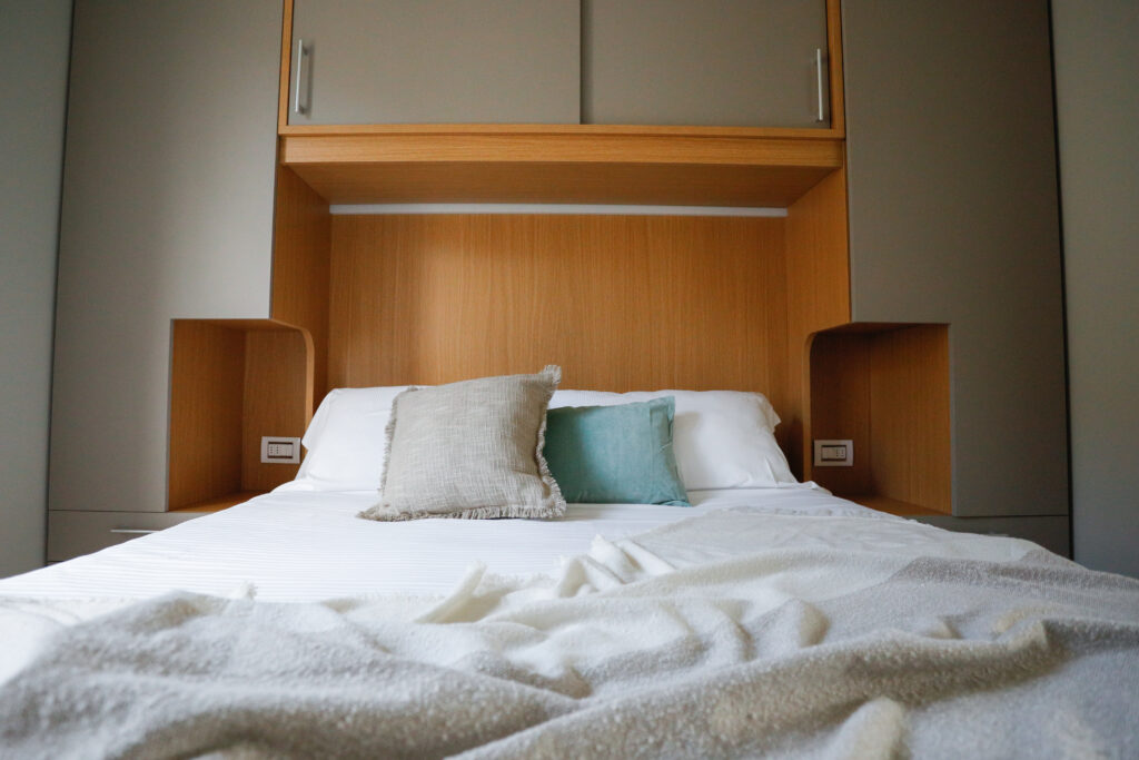 Cozy bedroom with warm wood headboard and white linens