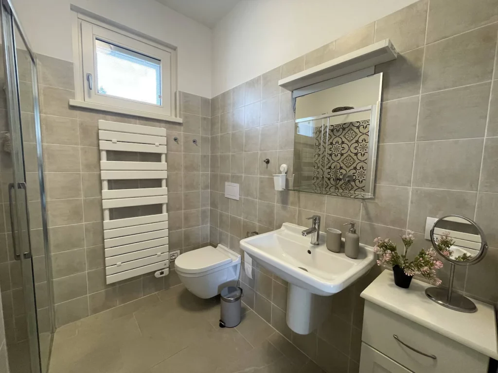 A contemporary bathroom design featuring a walk-in shower and elegant tiling in Wonder House