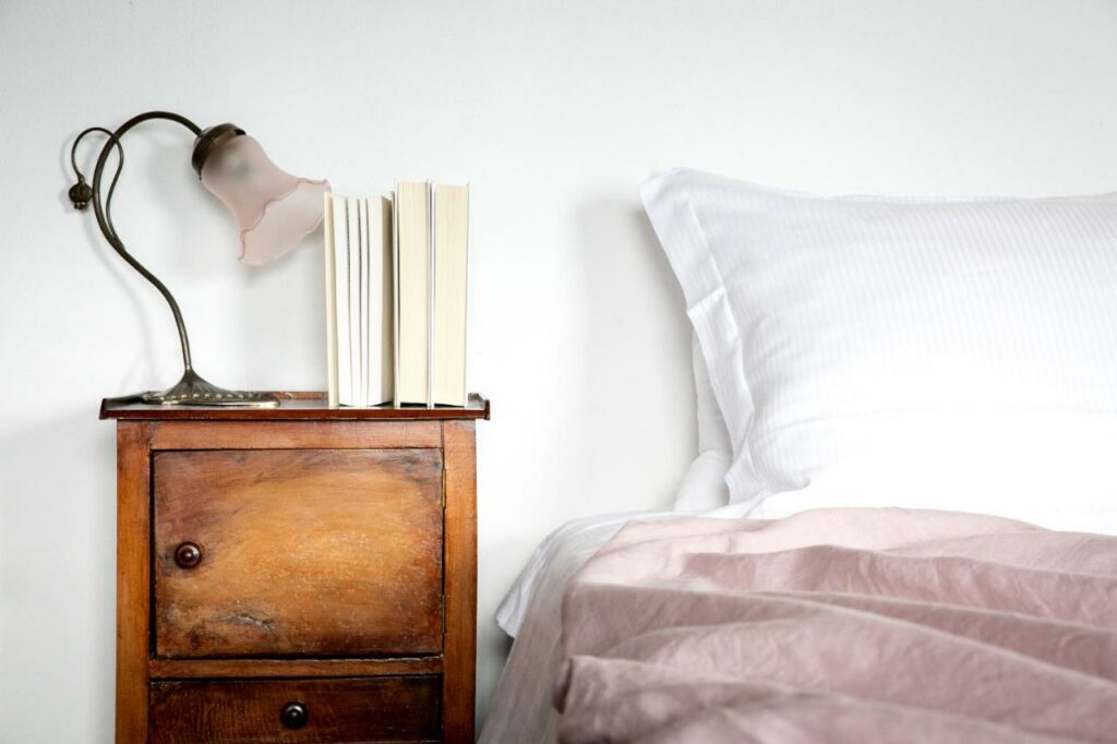 Cozy bedroom corner with vintage bedside table and classic lamp in La Stallina Penthouse