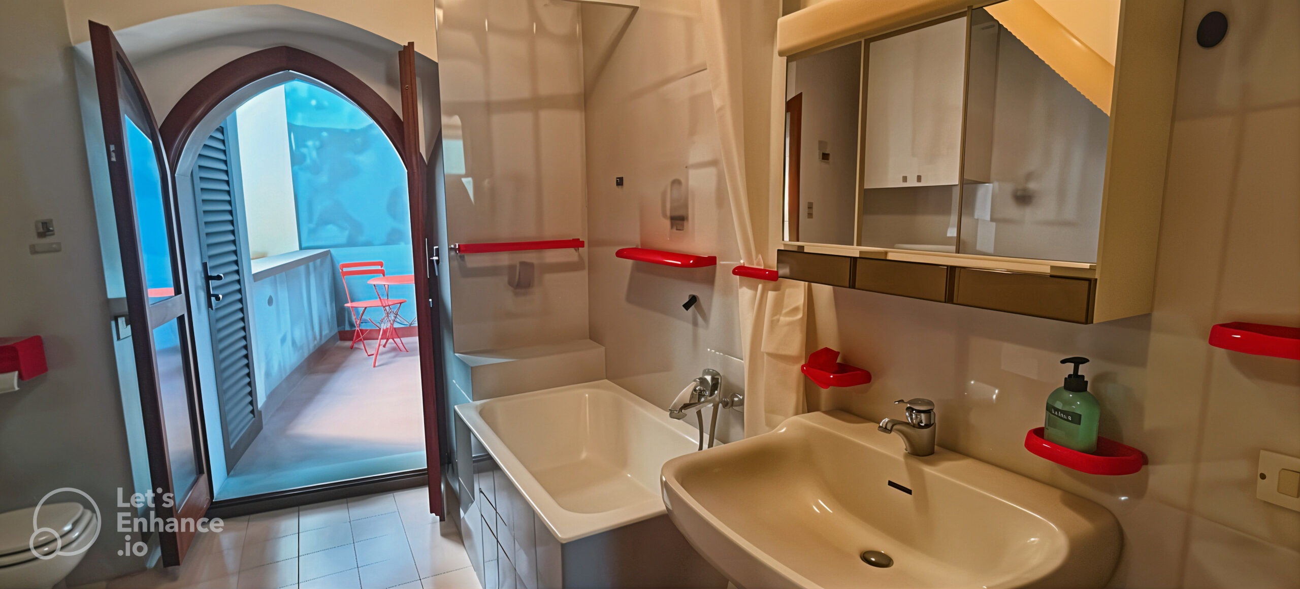 Bathroom with bathtub and sink, leading to a balcony with seating in La Porta Sul Lago apartment