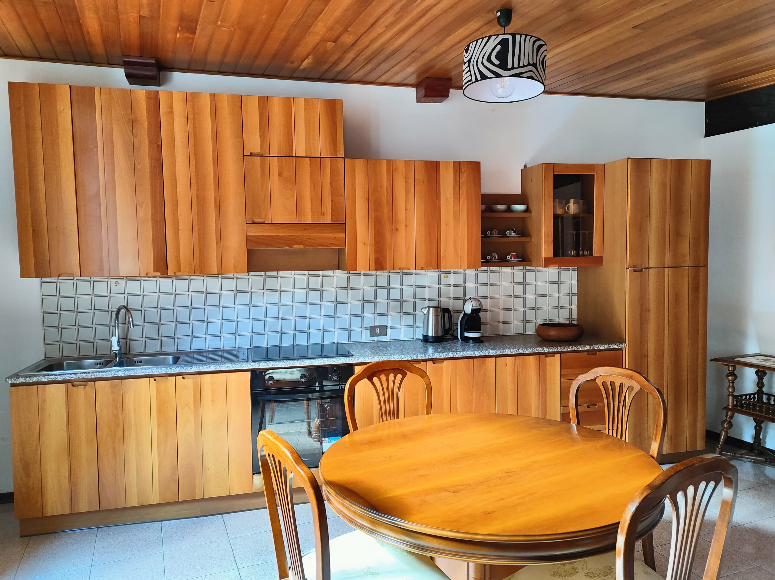 Fully equipped kitchen with wooden cabinets in La Porta Sul Lago apartment