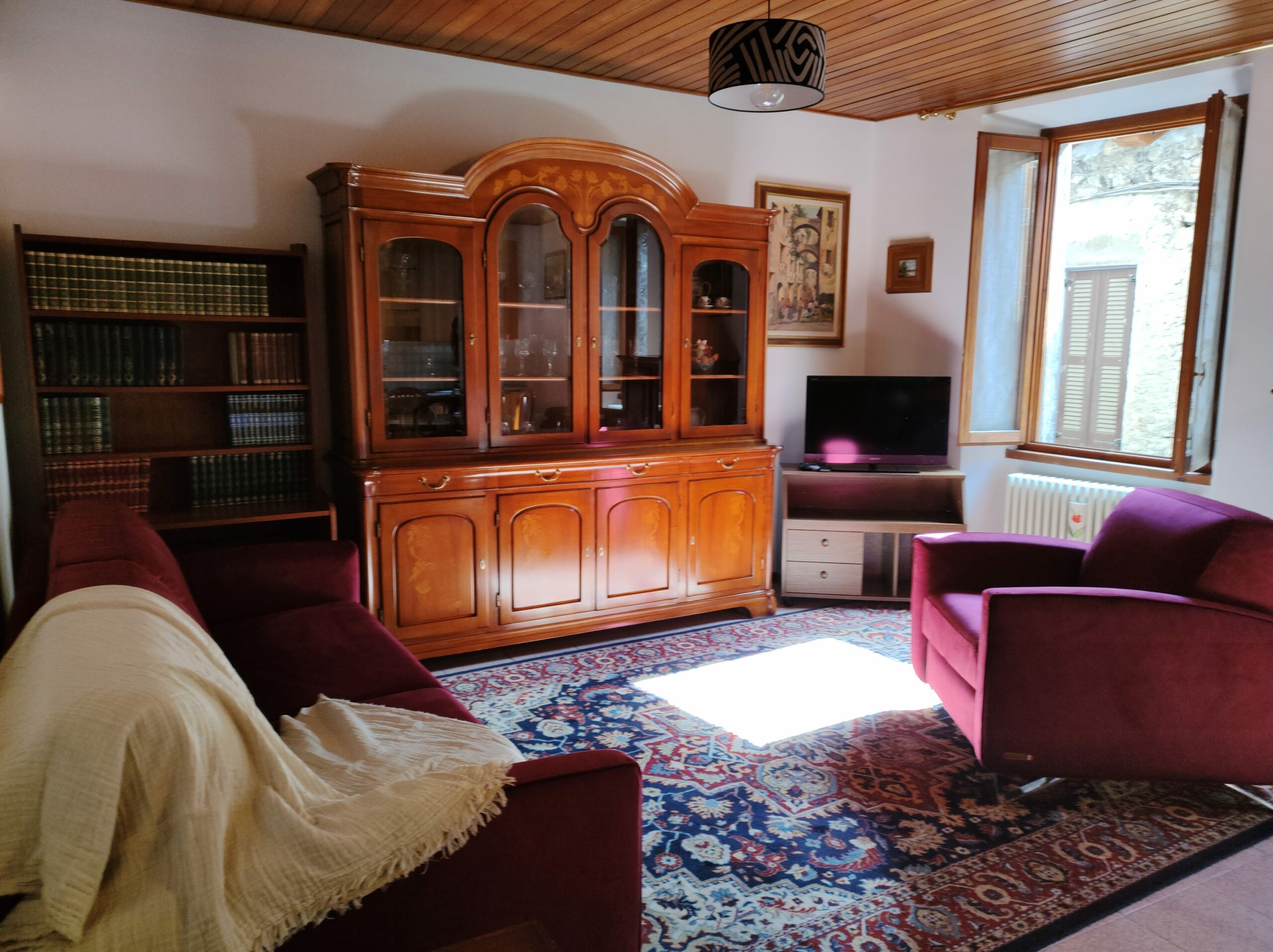 Living room with red sofas and wooden furniture in La Porta Sul Lago apartment