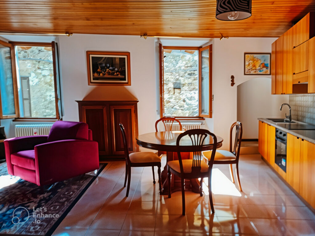 Living and dining area with wooden furniture and red armchair in La Porta Sul Lago apartment